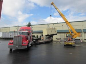 flatbed shipping truck carrying wide load over-dimensional freight